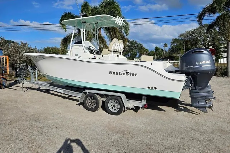 The Image of 2018 NauticStar 25 XS boat on trailer with Yamaha outboard motor, parked outdoors. - 0