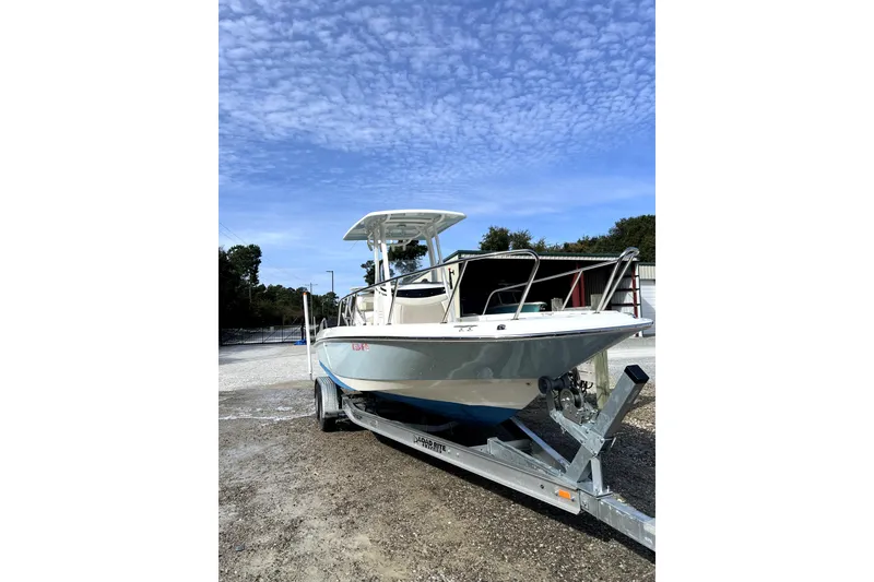 Slide: The Image of 2018 Boston Whaler 240 Dauntless boat on trailer under a clear blue sky. - 5