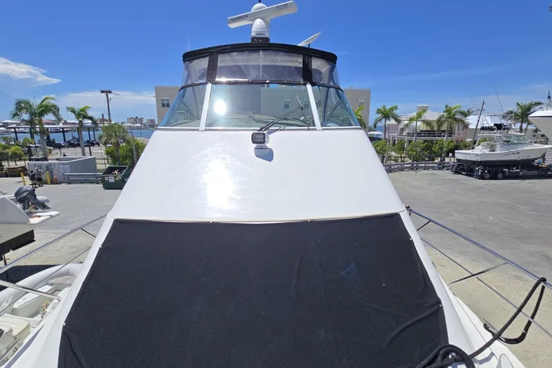 Slide: The Image of 2007 Cruisers Yachts 447 Sport Sedan docked, showcasing sleek design and spacious deck. - 11