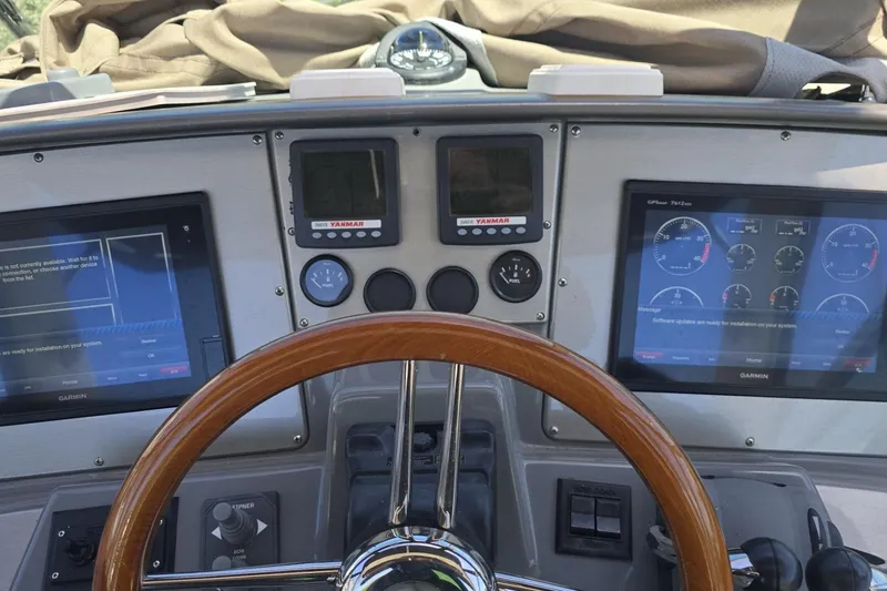 Slide: The Image of 2007 Cruisers Yachts 447 Sport Sedan helm with Garmin displays and wooden steering wheel. - 23
