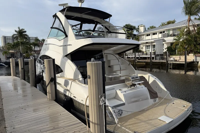 Slide: The Image of 2007 Cruisers Yachts 447 Sport Sedan docked at a marina, surrounded by palm trees. - 27