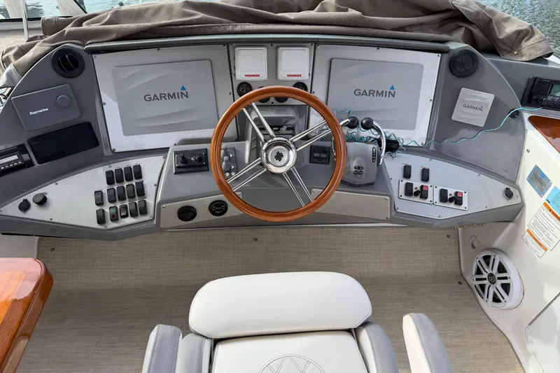 Slide: The Image of 2007 Cruisers Yachts 447 Sport Sedan helm with Garmin navigation displays and wooden steering wheel. - 53