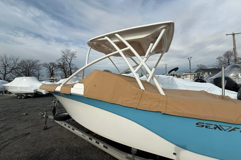 Slide: The Image of 2019 Sea Fox 226 Traveler boat with cover, parked on a trailer outdoors. - 19
