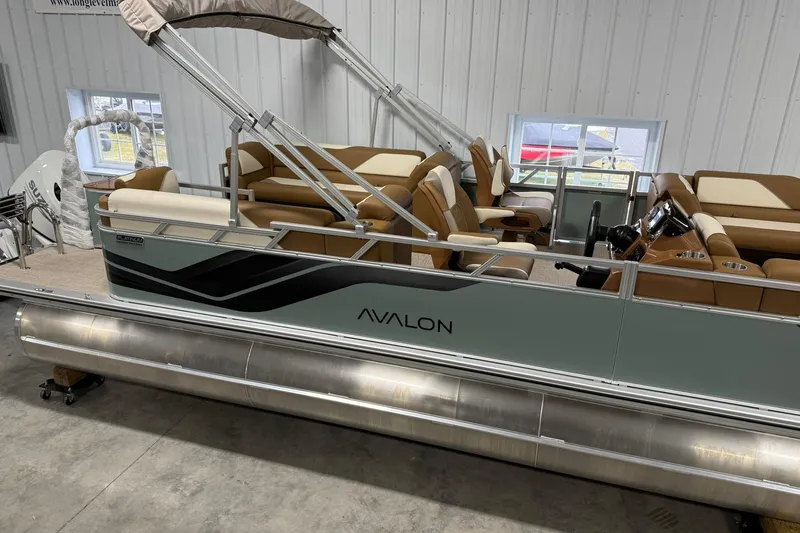 Slide: The Image of 2026 Avalon Venture Quad Lounge pontoon boat in showroom, featuring sleek design and comfortable seating. - 3