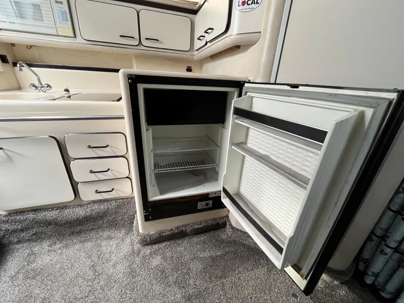 Slide: The Image of 1993 Sea Ray 330 Express kitchen area with open fridge. - 20