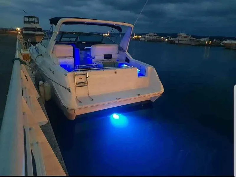 Slide: The Image of 1993 Sea Ray 330 Express with blue underwater lights in harbor. - 6