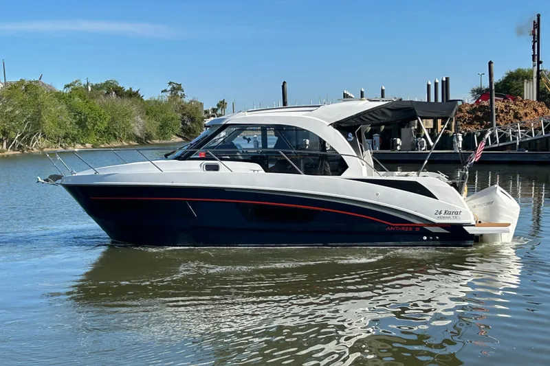 Slide: The Image of 2022 Beneteau Antares 9 boat cruising on a calm river with trees in the background. - 11