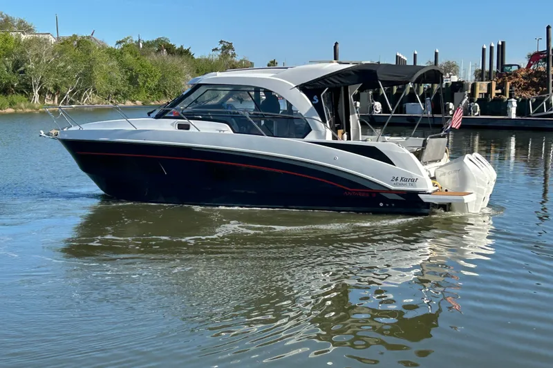 Slide: The Image of 2022 Beneteau Antares 9 boat cruising on calm water near a marina. - 12