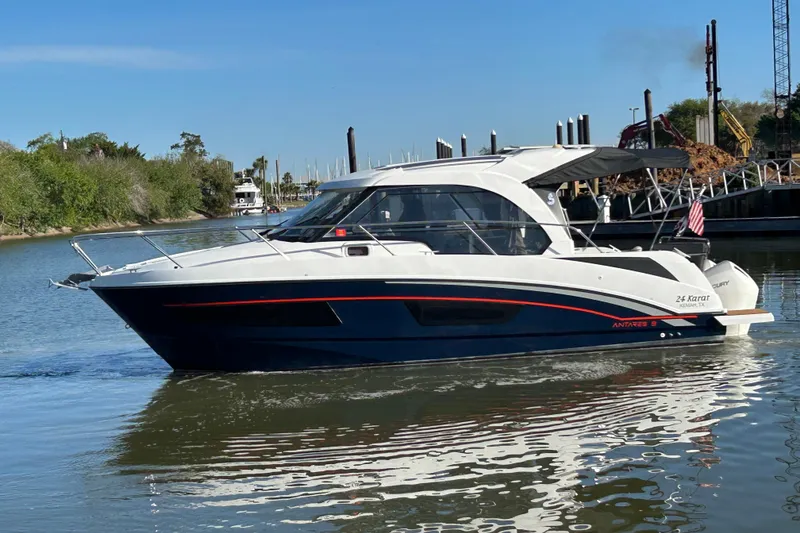 Slide: The Image of 2022 Beneteau Antares 9 boat cruising on a calm river with scenic background. - 15
