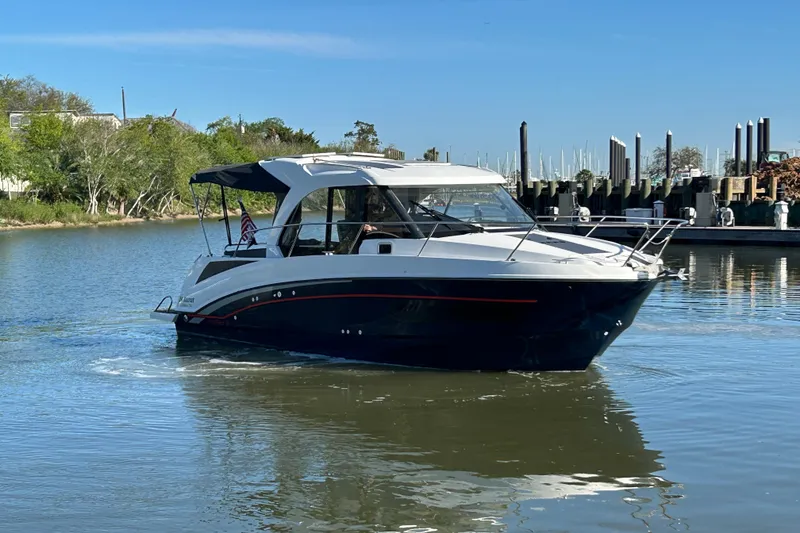 Slide: The Image of 2022 Beneteau Antares 9 cruising on a calm river near a marina. - 19
