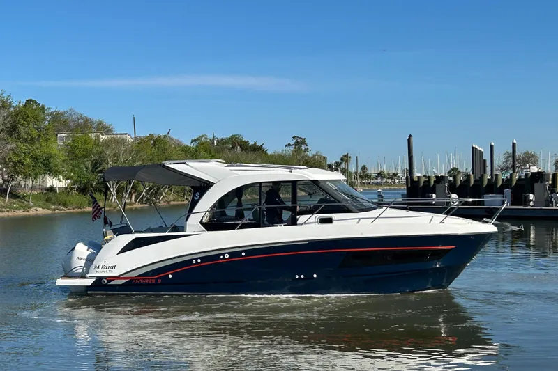 Slide: The Image of 2022 Beneteau Antares 9 boat cruising on a calm river near a marina. - 23