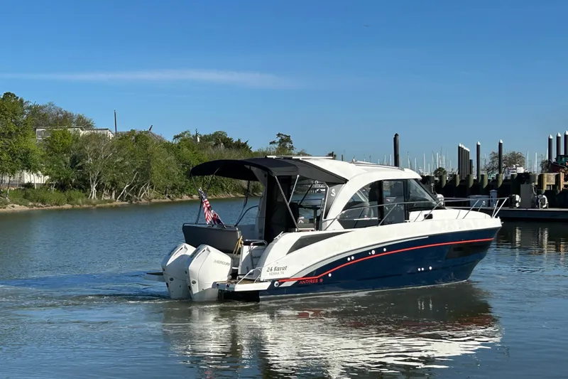 Slide: The Image of 2022 Beneteau Antares 9 boat cruising on a calm river near a marina. - 26