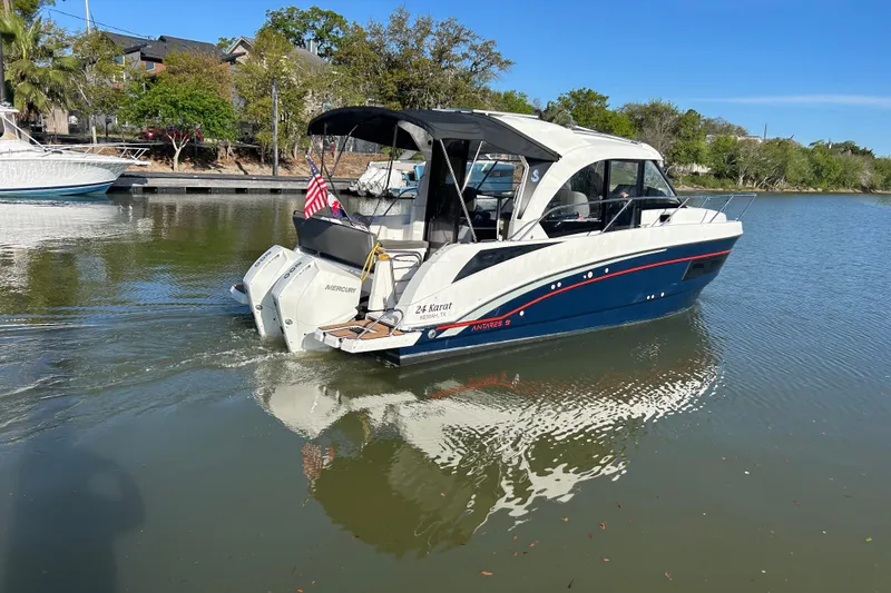 Slide: The Image of 2022 Beneteau Antares 9 boat cruising on a calm lake with trees in the background. - 3