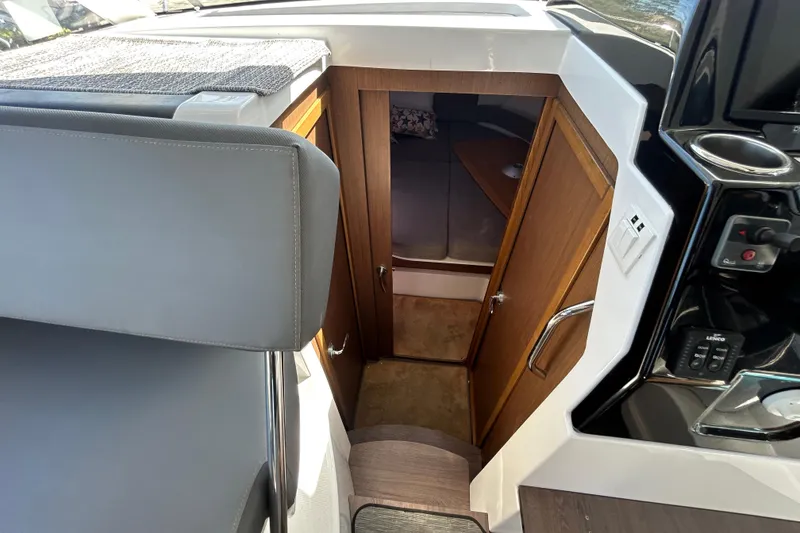 Slide: The Image of Interior cabin view of a 2022 Beneteau Antares 9 boat, featuring wooden door and seating. - 36