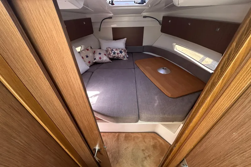 Slide: The Image of Cozy cabin interior of 2022 Beneteau Antares 9 with cushions and wooden accents. - 39