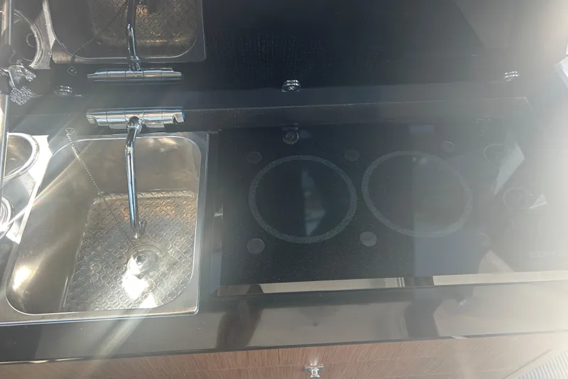 Slide: The Image of Modern kitchen area in a 2022 Beneteau Antares 9 boat, featuring a sink and stovetop. - 43