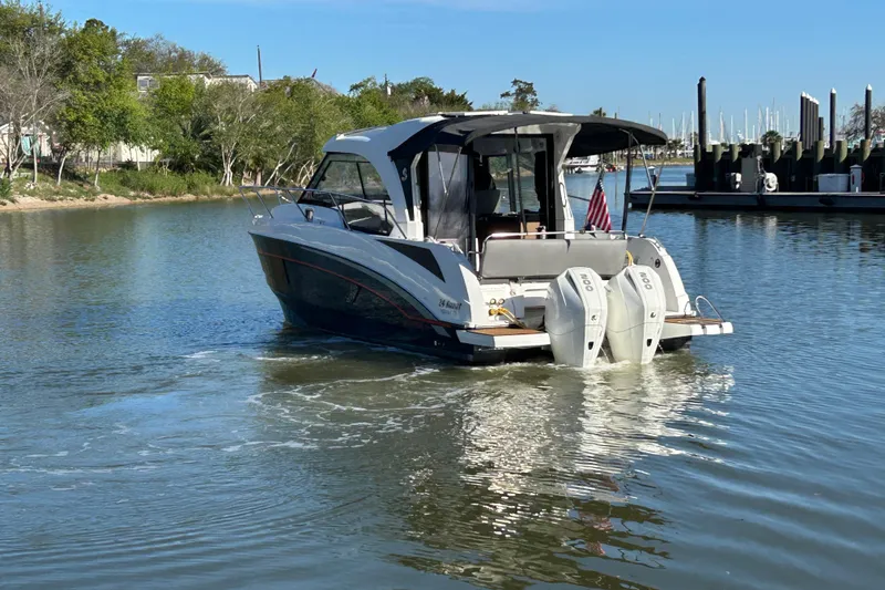 Slide: The Image of 2022 Beneteau Antares 9 cruising on a calm river with twin outboard engines. - 8