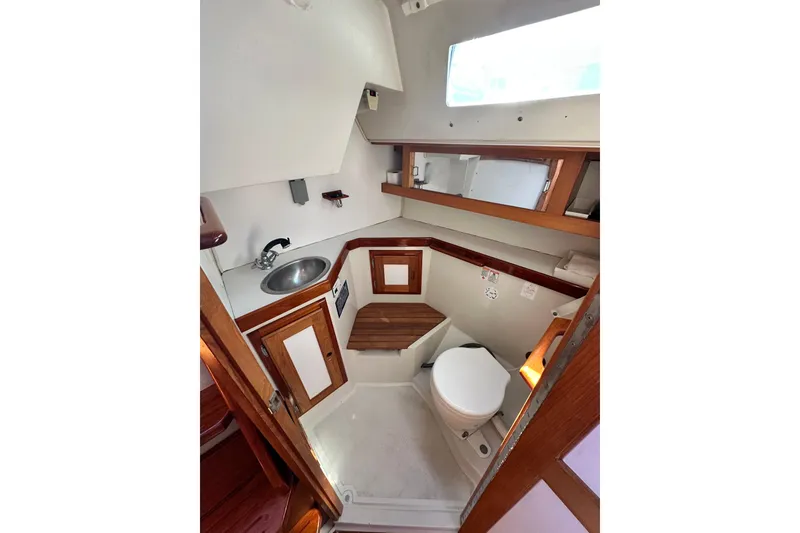 Slide: The Image of Interior of 1994 Catalina 34 MkII sailboat bathroom with sink, toilet, and wooden accents. - 12