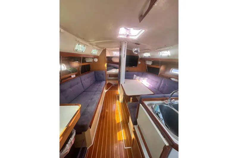 Slide: The Image of Interior of 1994 Catalina 34 MkII sailboat with cozy seating and wooden flooring. - 3