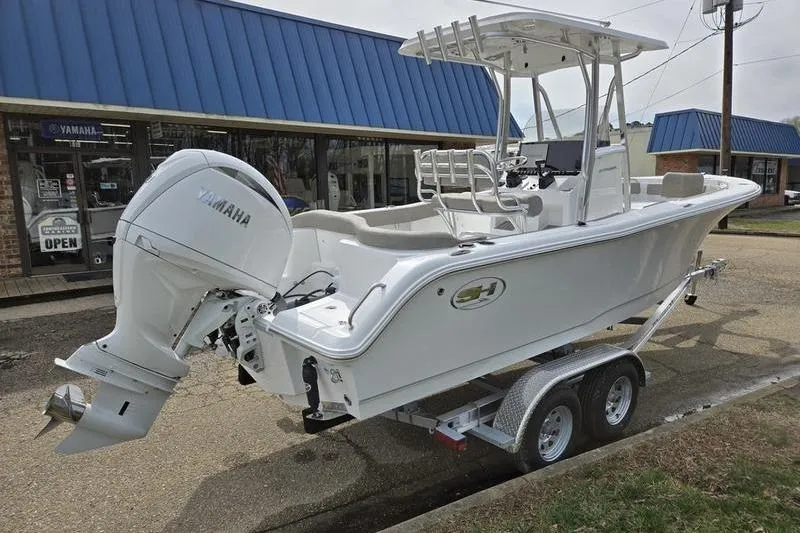 Slide: The Image of 2025 Sea Hunt Ultra 229 boat on trailer, parked outside a Yamaha dealership. - 6
