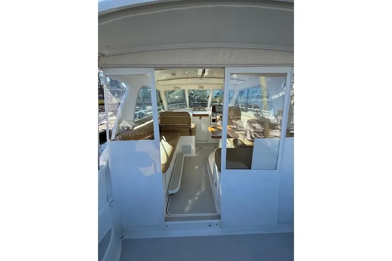 Slide: The Image of 2018 Back Cove 30 boat interior with seating and helm, viewed from the entrance. - 13