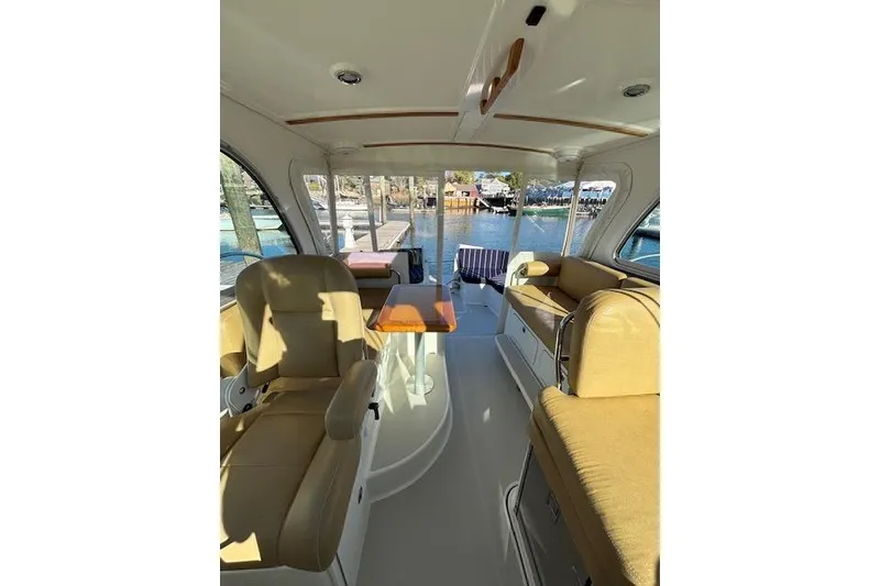 Slide: The Image of Interior of a 2018 Back Cove 30 boat with beige seating and a wooden table. - 14