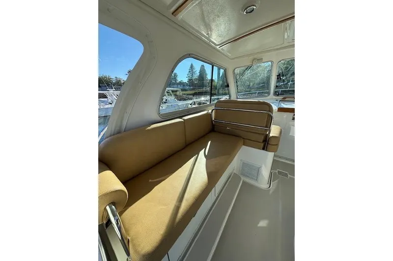 Slide: The Image of Interior of 2018 Back Cove 30 boat with tan seating and large windows. - 15