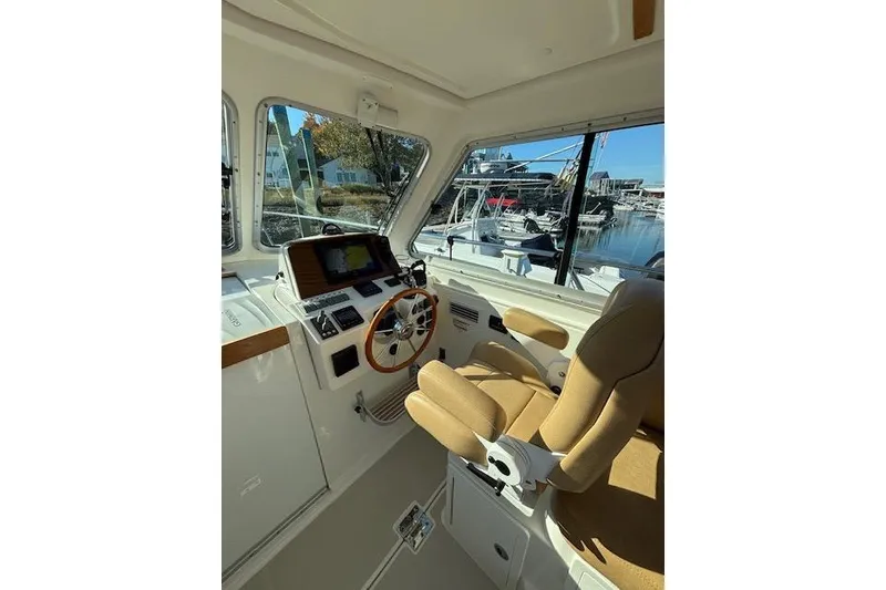 Slide: The Image of 2018 Back Cove 30 boat interior with helm, steering wheel, and navigation equipment. - 19