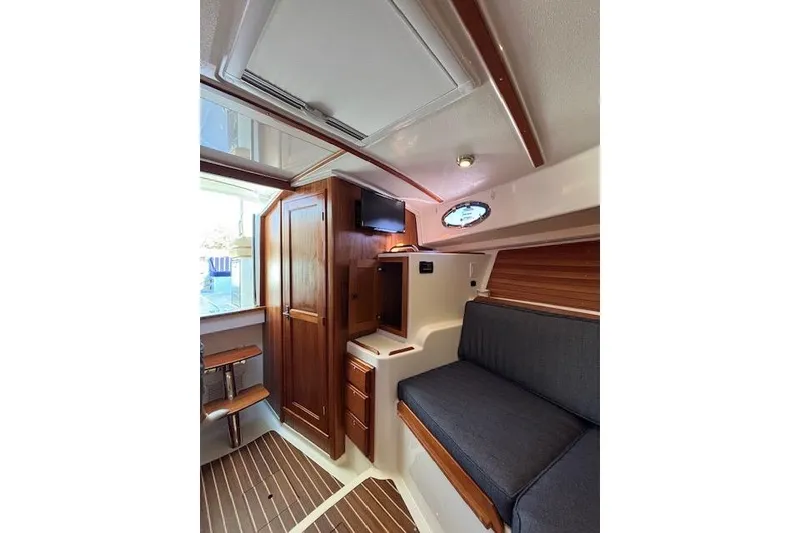 Slide: The Image of 2018 Back Cove 30 interior with wood accents, seating, and storage. - 22