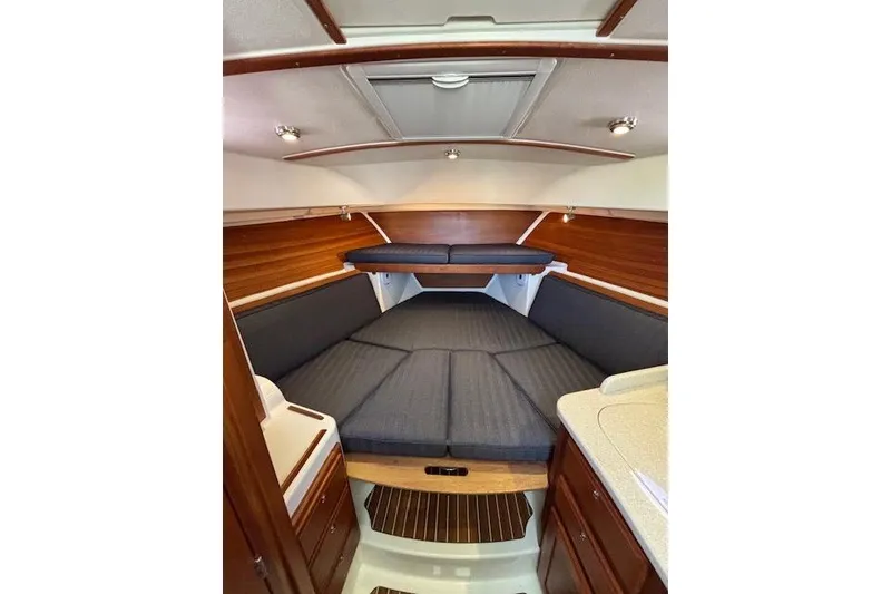 Slide: The Image of 2018 Back Cove 30 interior cabin with wood accents and cushioned seating. - 26