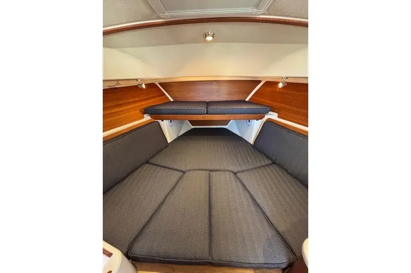Slide: The Image of 2018 Back Cove 30 interior cabin with cushioned seating and wooden accents. - 27
