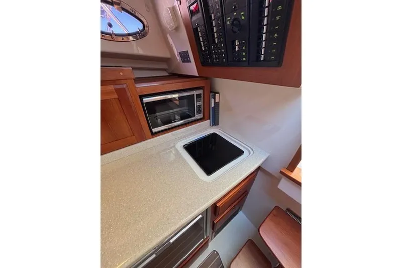 Slide: The Image of 2018 Back Cove 30 yacht interior galley with microwave and control panel. - 31