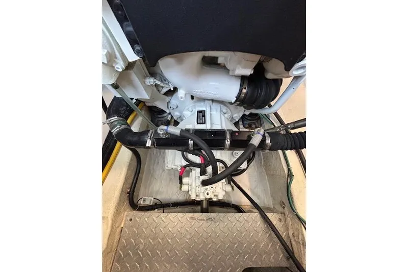 Slide: The Image of Engine compartment of a 2018 Back Cove 30 boat, showcasing mechanical components and hoses. - 42