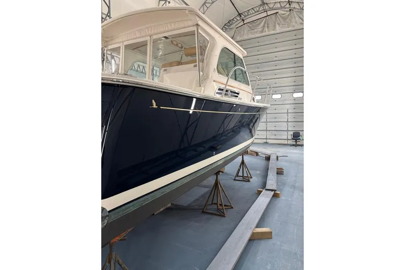 Slide: The Image of 2015 Back Cove 30 boat in storage, showcasing sleek design and navy blue hull. - 51