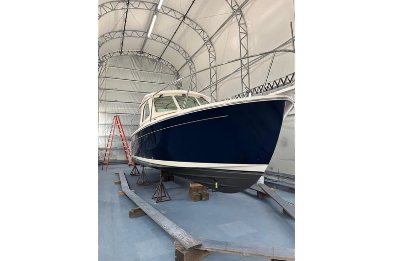 Slide: The Image of 2015 Back Cove 30 boat in storage, blue hull, indoor facility. - 53