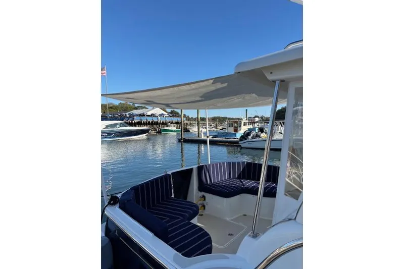 Slide: The Image of 2018 Back Cove 30 boat with striped seating, docked in a sunny marina. - 7