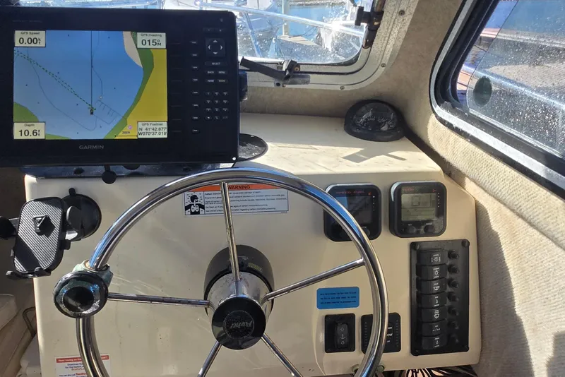 Slide: The Image of Steering wheel and navigation system inside a 2007 Parker 2320 SL Sport Cabin boat. - 12