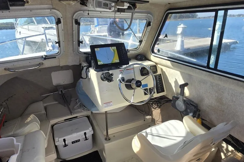 Slide: The Image of 2007 Parker 2320 SL Sport Cabin boat docked at marina, spacious deck area. - 4