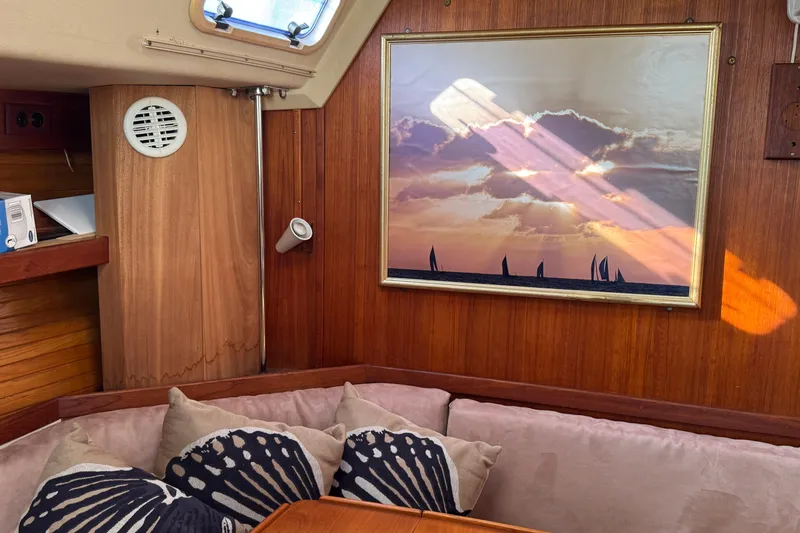 Slide: The Image of Cozy Catalina 42 yacht interior with sunset painting, cushions, and wooden paneling. - 21