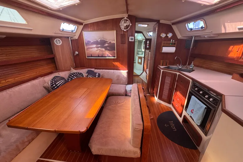 Slide: The Image of Interior of a 1989 Catalina 42 sailboat with cozy seating and a compact kitchen. - 27