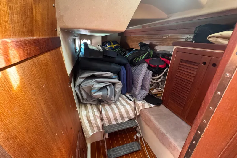 Slide: The Image of Cozy cabin interior of a 1989 Catalina 42 sailboat with storage and wooden finishes. - 36