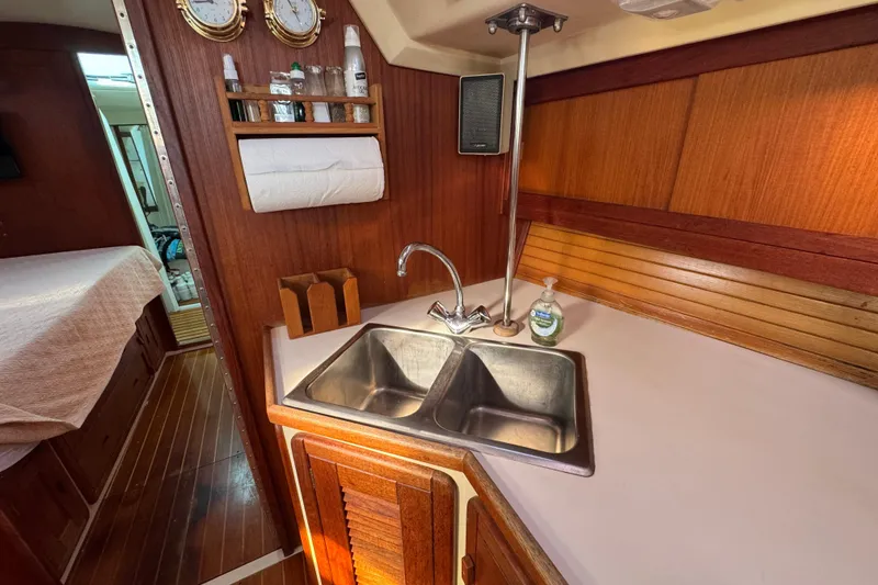 Slide: The Image of Galley of 1989 Catalina 42 sailboat with wooden cabinetry and dual sink. - 41