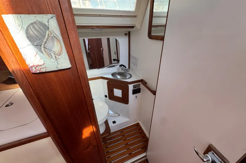 Slide: The Image of Interior of 1989 Catalina 42 sailboat bathroom with wooden accents and nautical decor. - 43