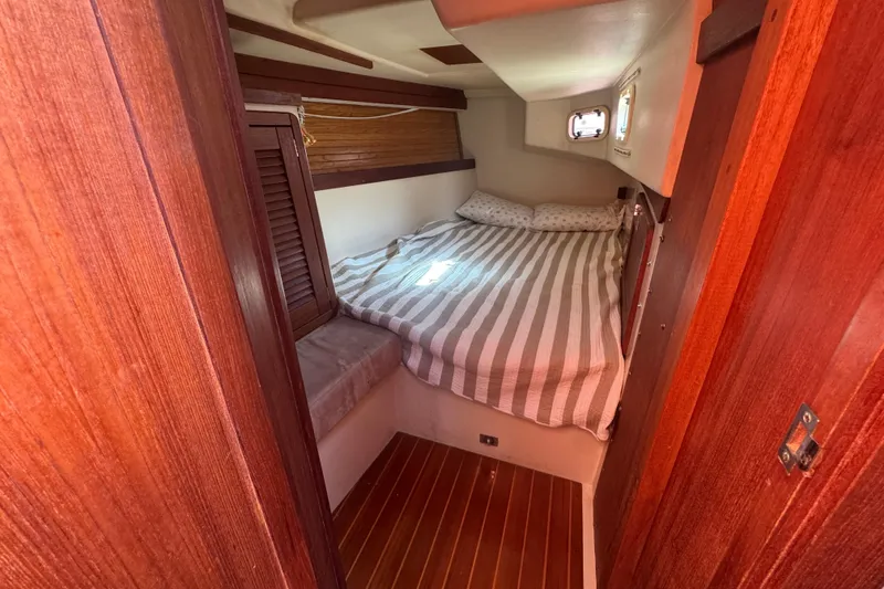 Slide: The Image of Cozy cabin interior of 1989 Catalina 42 sailboat with striped bedding and wooden accents. - 45