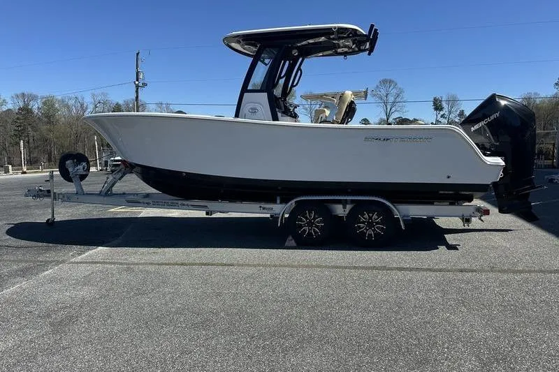 The Image of 2026 Sportsman Open 232 Center Console boat on trailer in parking lot. - 1