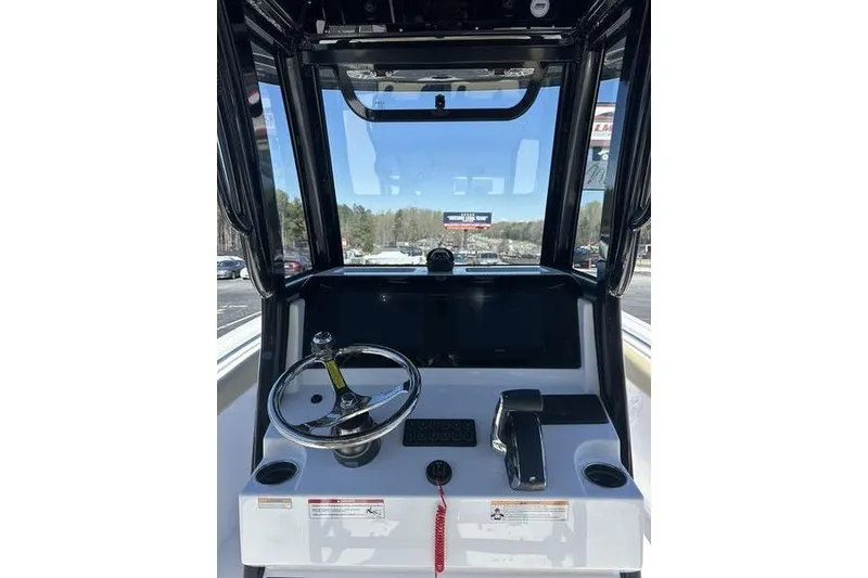 Slide: The Image of 2026 Sportsman Open 232 Center Console boat dashboard with steering wheel and controls. - 11