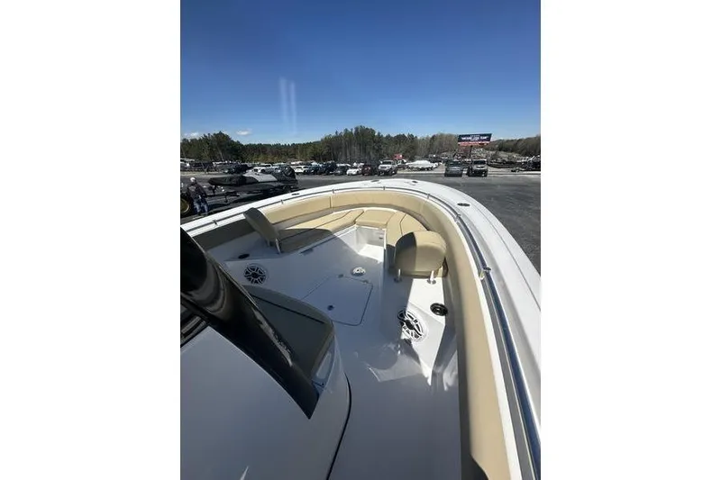 Slide: The Image of 2026 Sportsman Open 232 Center Console boat with beige seating, parked outdoors. - 19