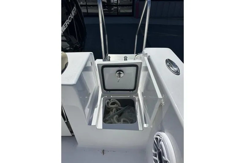 Slide: The Image of 2026 Sportsman Open 232 Center Console boat with open storage compartment and coiled rope. - 6