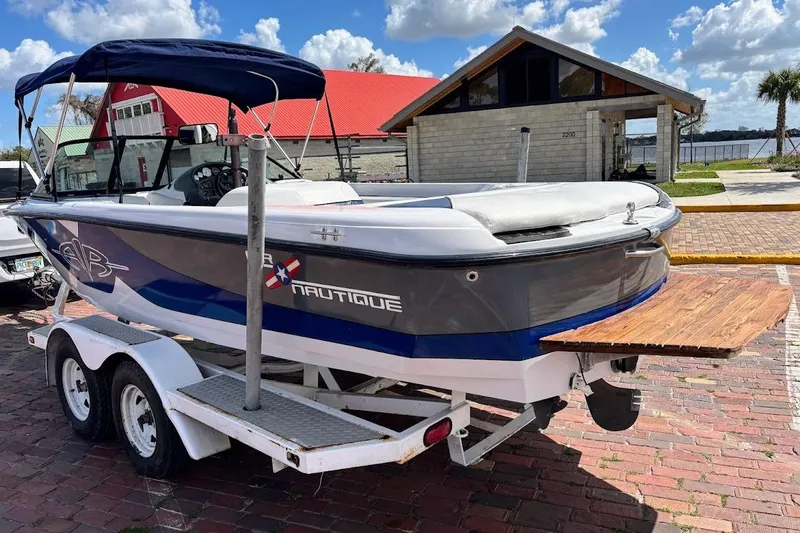 Slide: The Image of 2001 Nautique Air Nautique 210 boat on trailer, parked near waterfront building. - 7