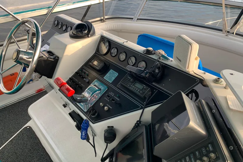 Slide: The Image of Control panel of a 1994 Carver 440 Aft Cabin Motor Yacht with steering wheel and gauges. - 11
